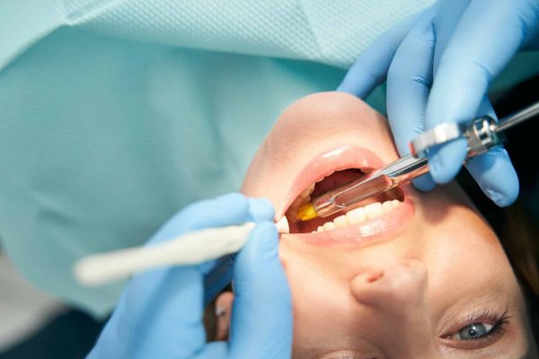 Woman receiving dental treatment in stomatology clinic